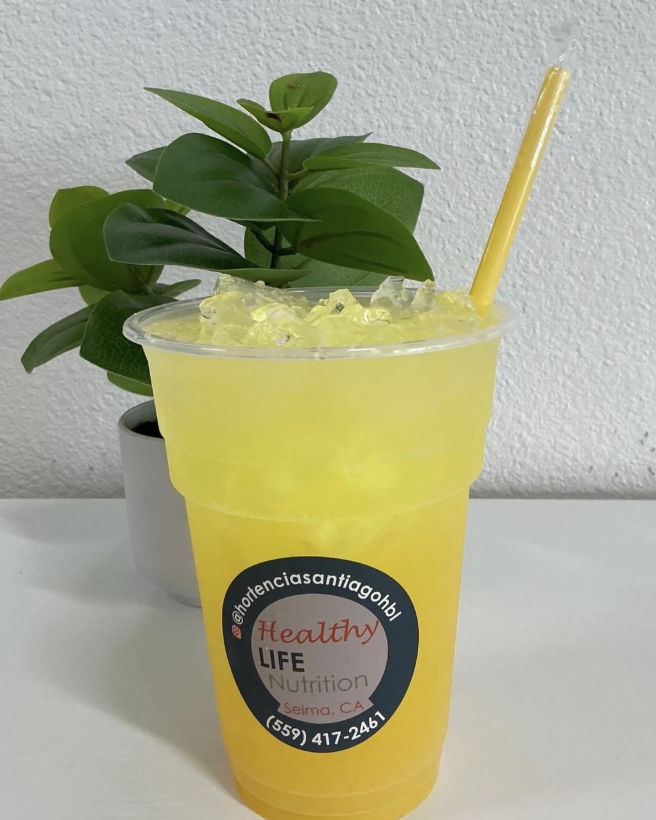 Bright yellow energy drink with ice and straw.